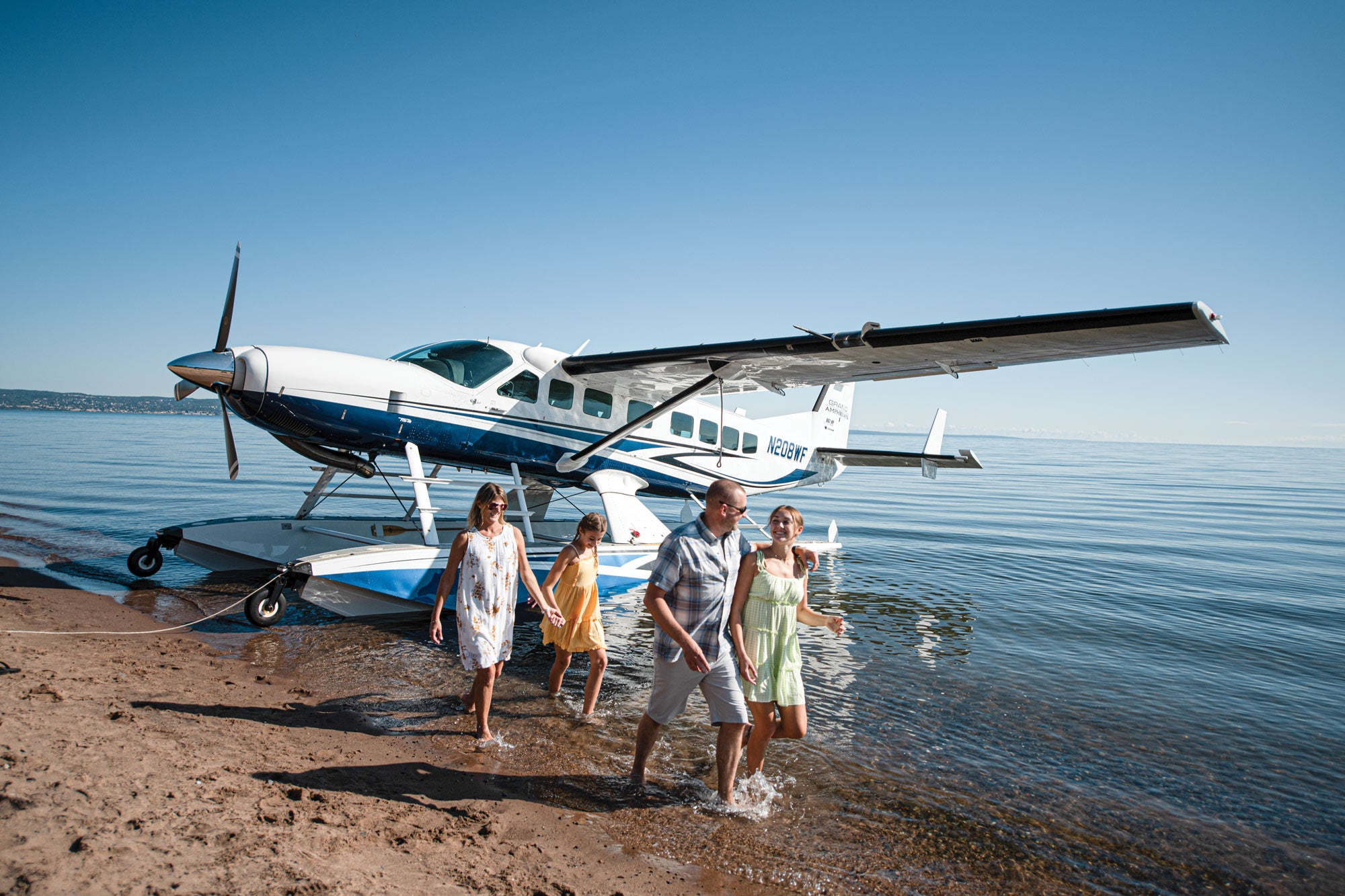 family walking away from floatplane on the beach